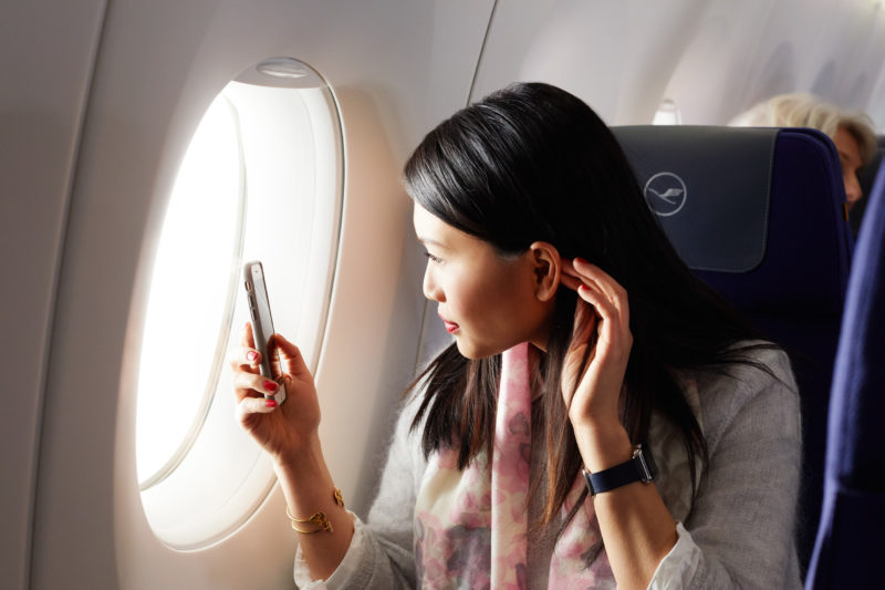 a woman looking at her phone in a plane