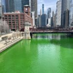 a green river with Chicago River and buildings in the background