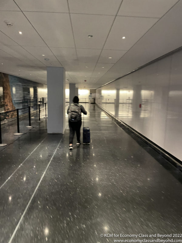 a person with a luggage bag walking down a hallway
