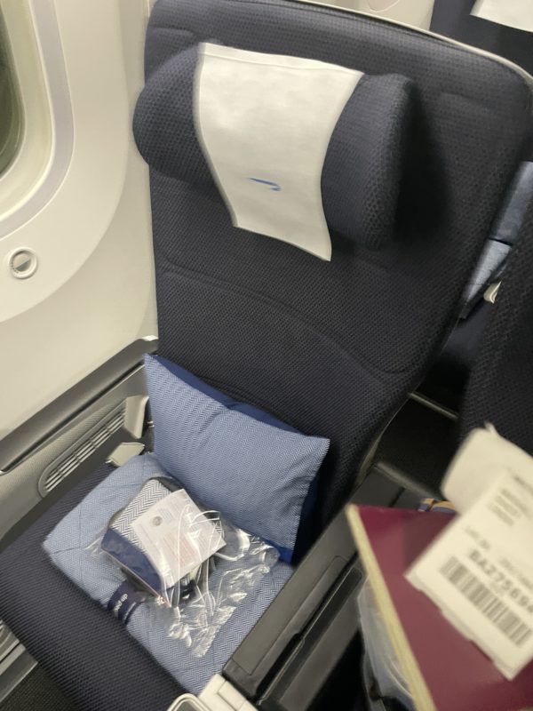 a seat with a pillow and a white roll of paper on it