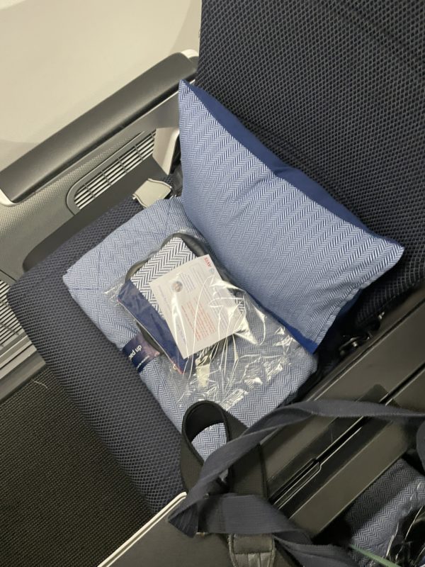 a seat with a pillow and a bag on it