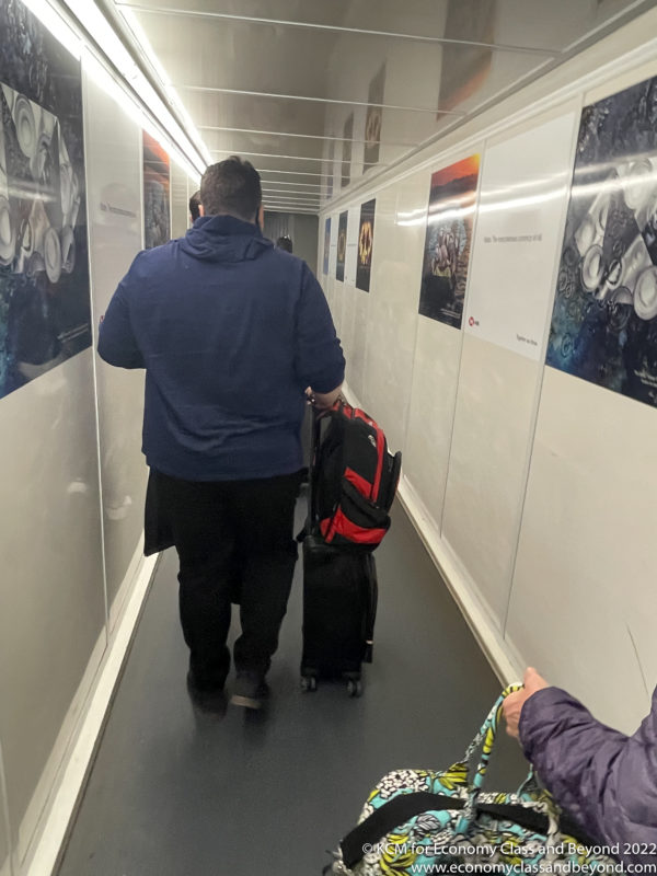 a man pulling a luggage bag in a hallway