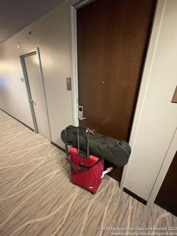 a red suitcase with a black bag on top of it