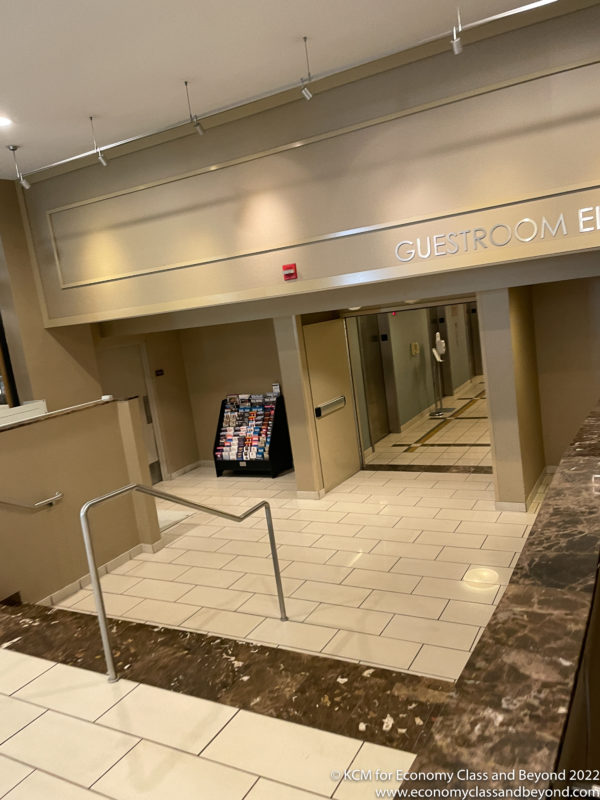 a lobby with a marble floor and a handrail