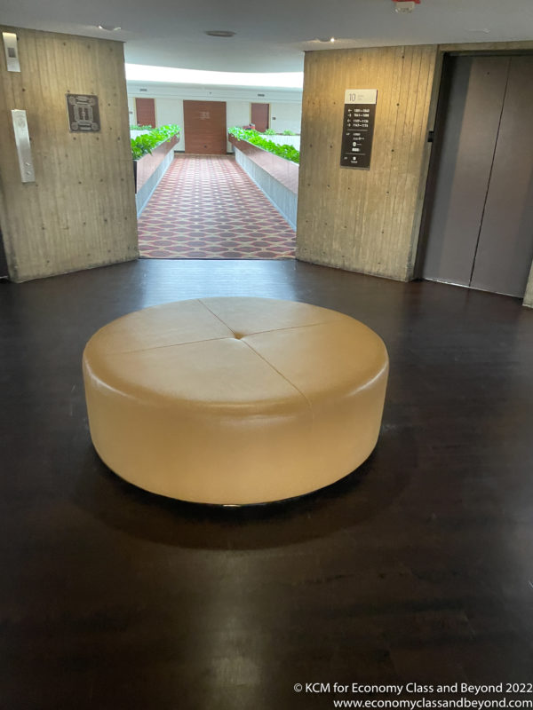 a round leather seat in a room with doors and plants