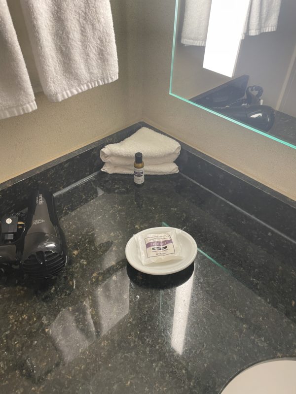 a bathroom counter with a mirror and a towel and a dish