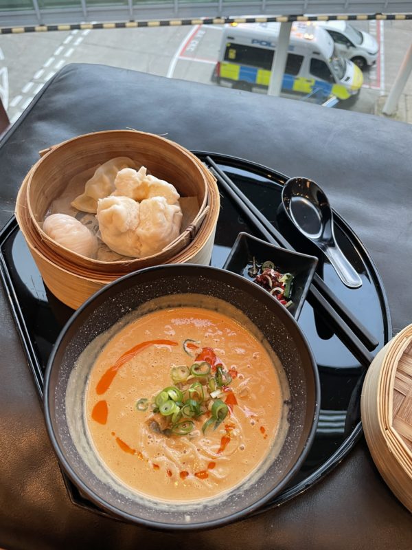 a bowl of soup and dumplings on a tray
