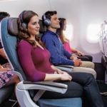 people sitting in a plane with people wearing headphones
