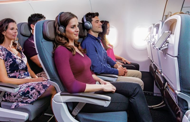 people sitting in a plane with headphones