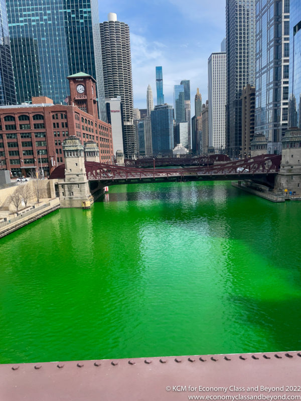 a green river with Chicago River and buildings in the background