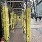 a group of yellow poles on a sidewalk