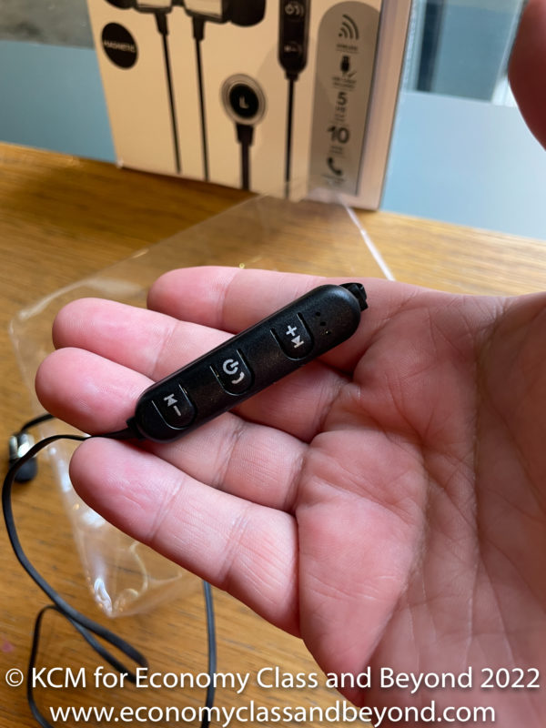 a hand holding a black earbud