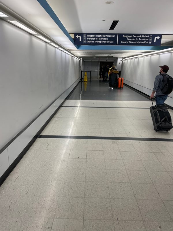 a man with luggage in a hallway
