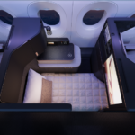 an airplane cabin with a bed and a tv
