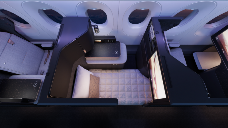 an airplane cabin with a bed and a table