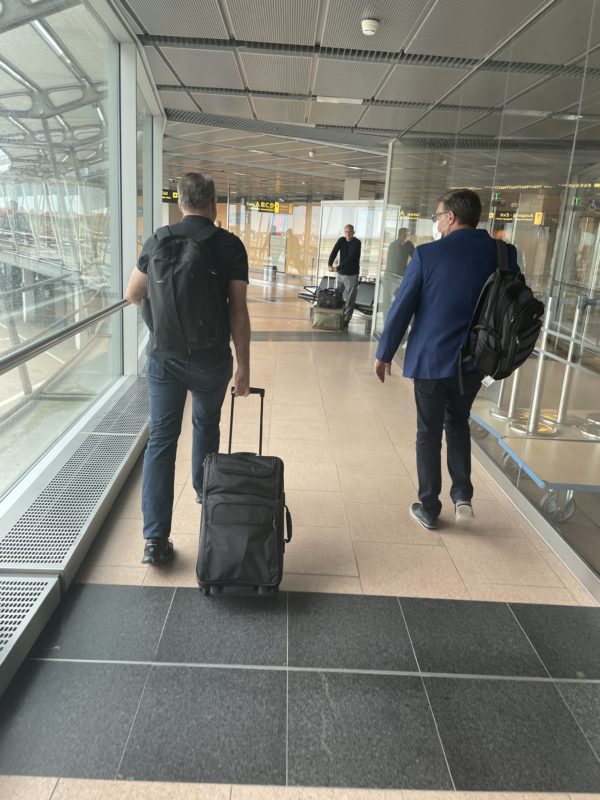 a group of men with luggage in an airport