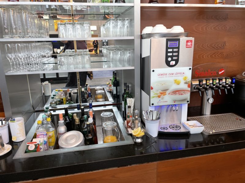 a bar with a beverage dispenser and glasses