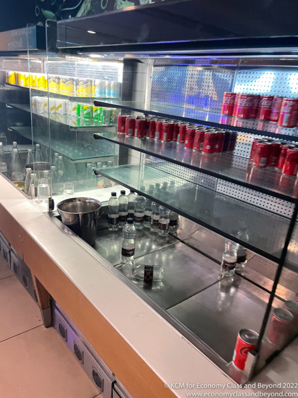 a display case with drinks and cans