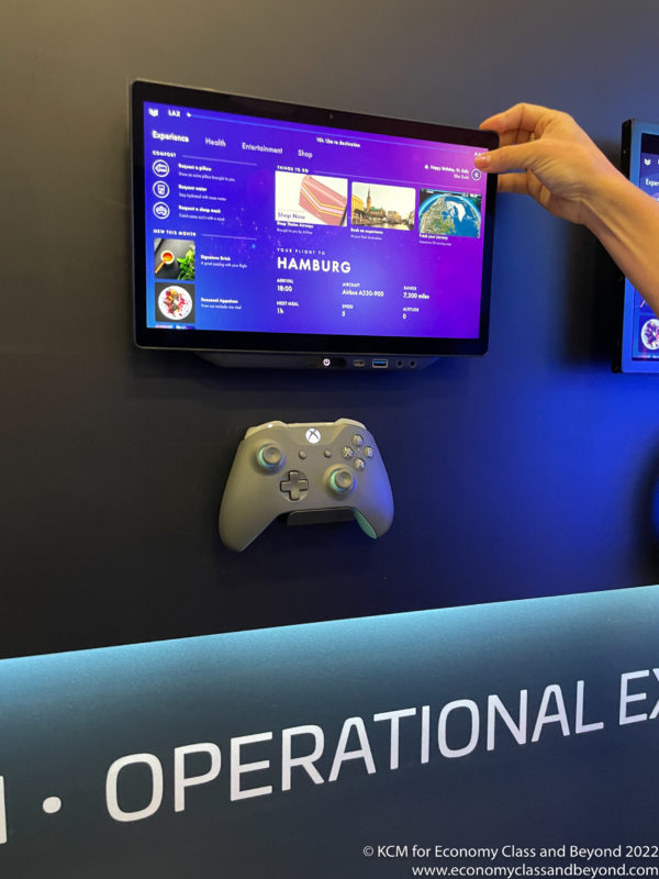 a hand holding a screen with a game controller on the wall