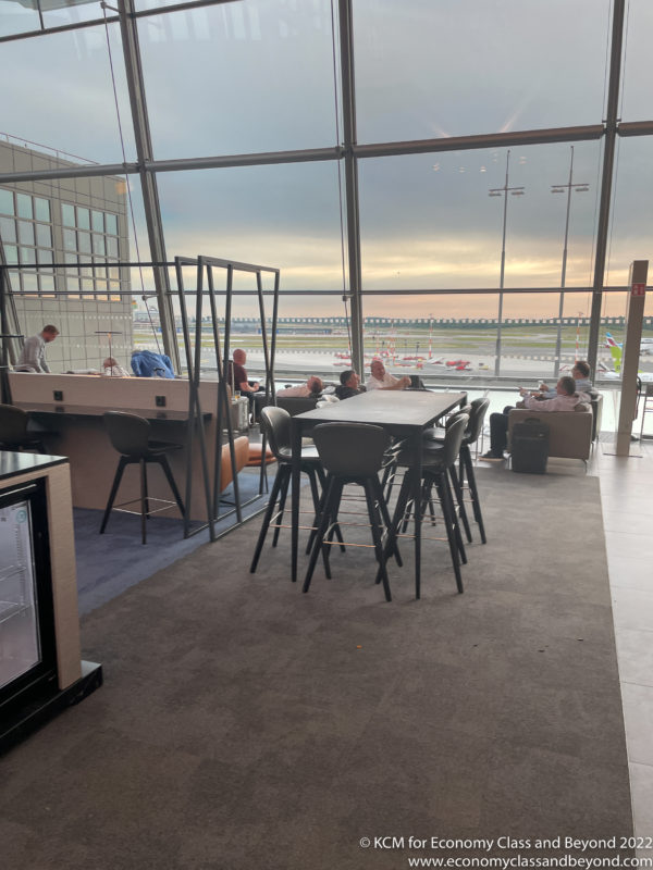 a group of people sitting at tables in an airport