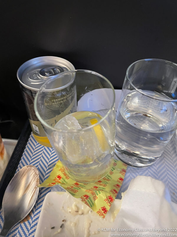 a group of glasses and a can of soda on a tray