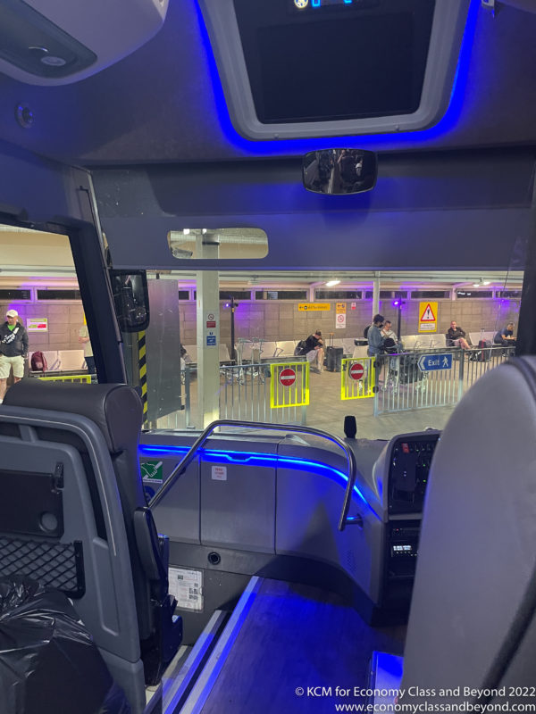 inside a bus with seats and a blue light