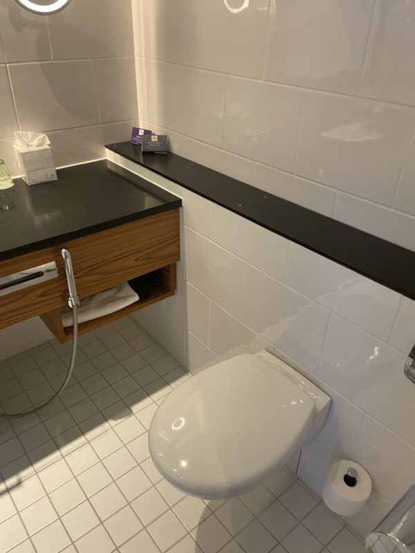 a bathroom with a black counter top and white tile walls