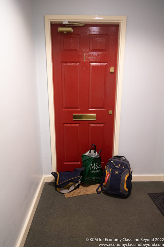 a red door with a couple of bags on it