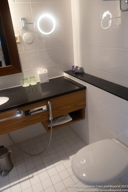 a bathroom with a black counter top and a white toilet