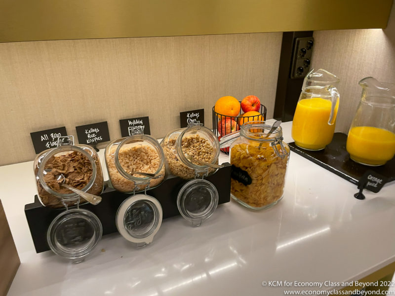 a group of cereals and cereal in containers on a counter