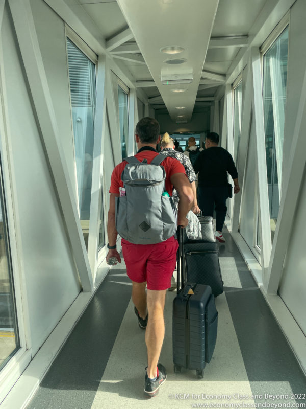 a man with luggage walking down a walkway