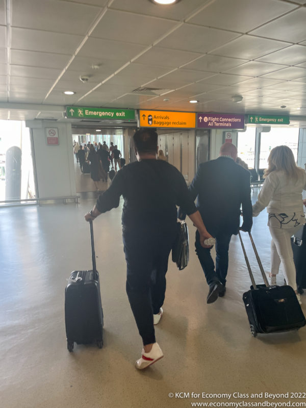 a group of people walking with luggage in an airport