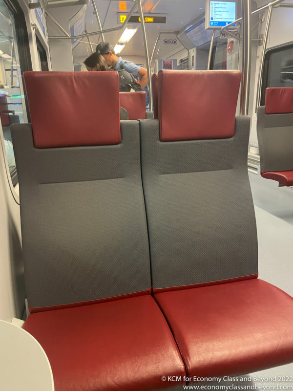 a red and grey seats on a train