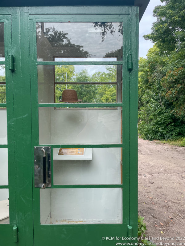 a green phone booth with a hat on it