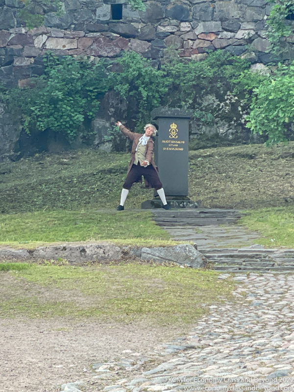a man standing in a park with a sword