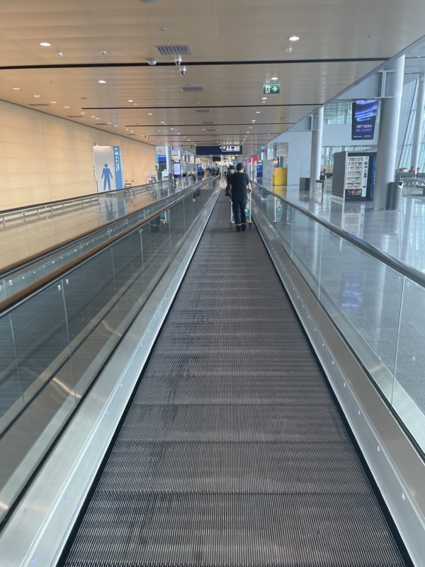 a person on a moving walkway in a building