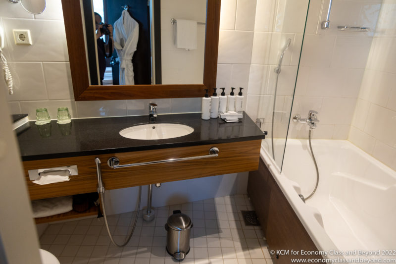 a bathroom with a mirror and a bathtub