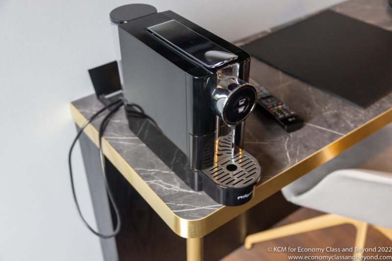a black coffee machine on a marble table