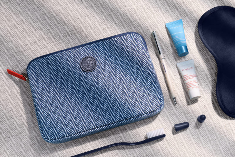 a blue and white bag with a few small objects on it