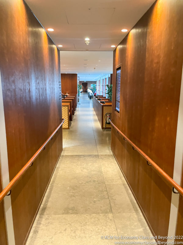 a long hallway with wood walls and a railing