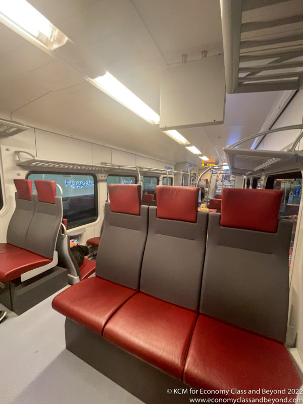 a red and grey seats in a train