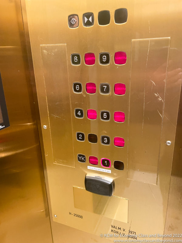 a gold elevator with buttons and numbers