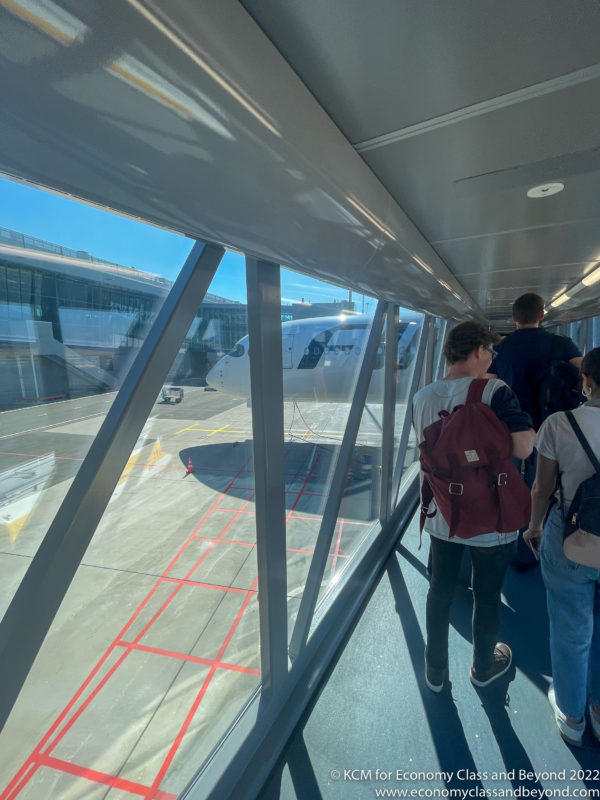 people standing in a hallway with a plane in the background
