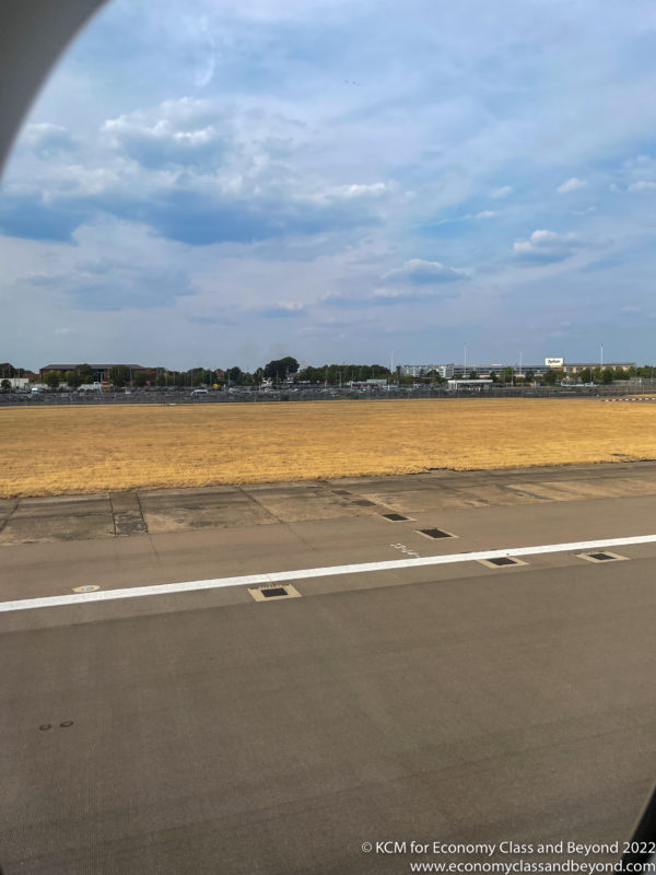 a runway with a field and a fence