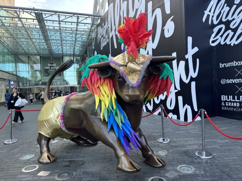 a statue of a bull with colorful feathers