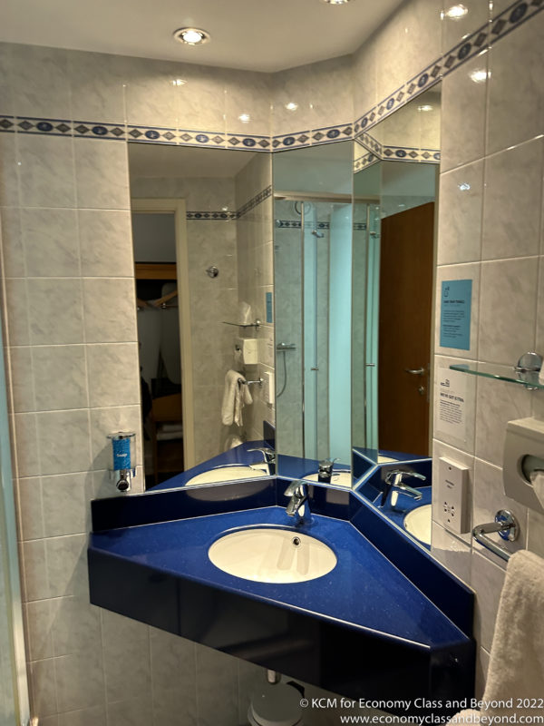 a bathroom with a blue countertop and a mirror