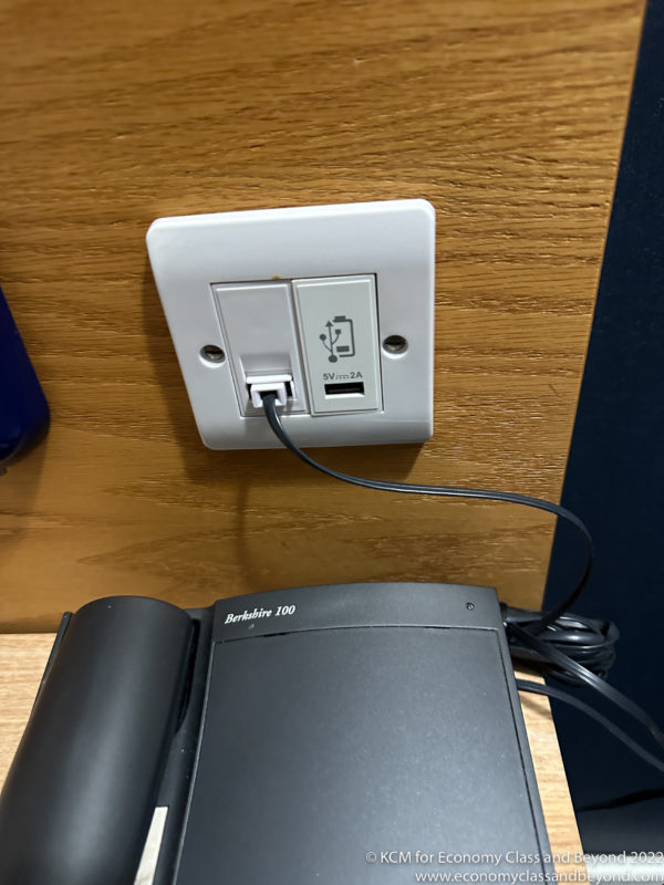 a white rectangular outlet with a black cord plugged into it