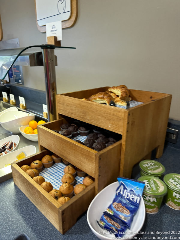 a wood trays with pastries and muffins on a counter