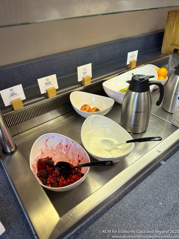 a counter with bowls of fruit and a spoon