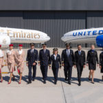 a group of people in uniform standing in front of airplanes